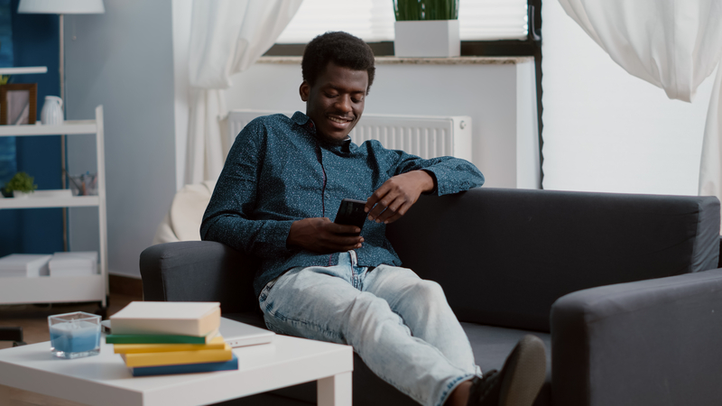 Young Man Looking At Social Media With A Smile Of Contentment